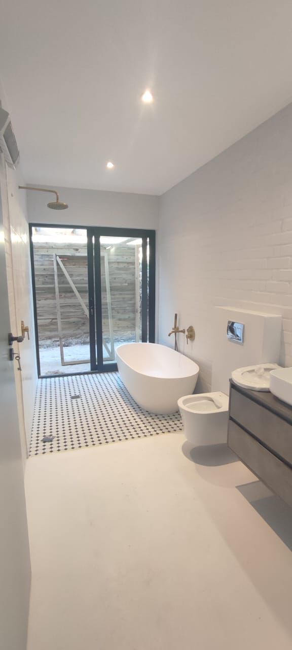 Finished bathroom with freestanding bath and wall-mounted fittings