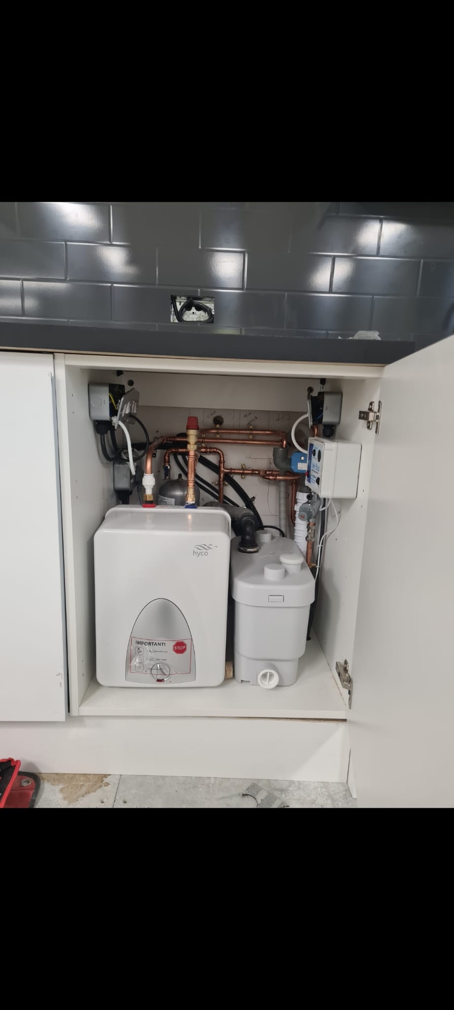 Finished service cabinet with small water heater, pump and copper pipework