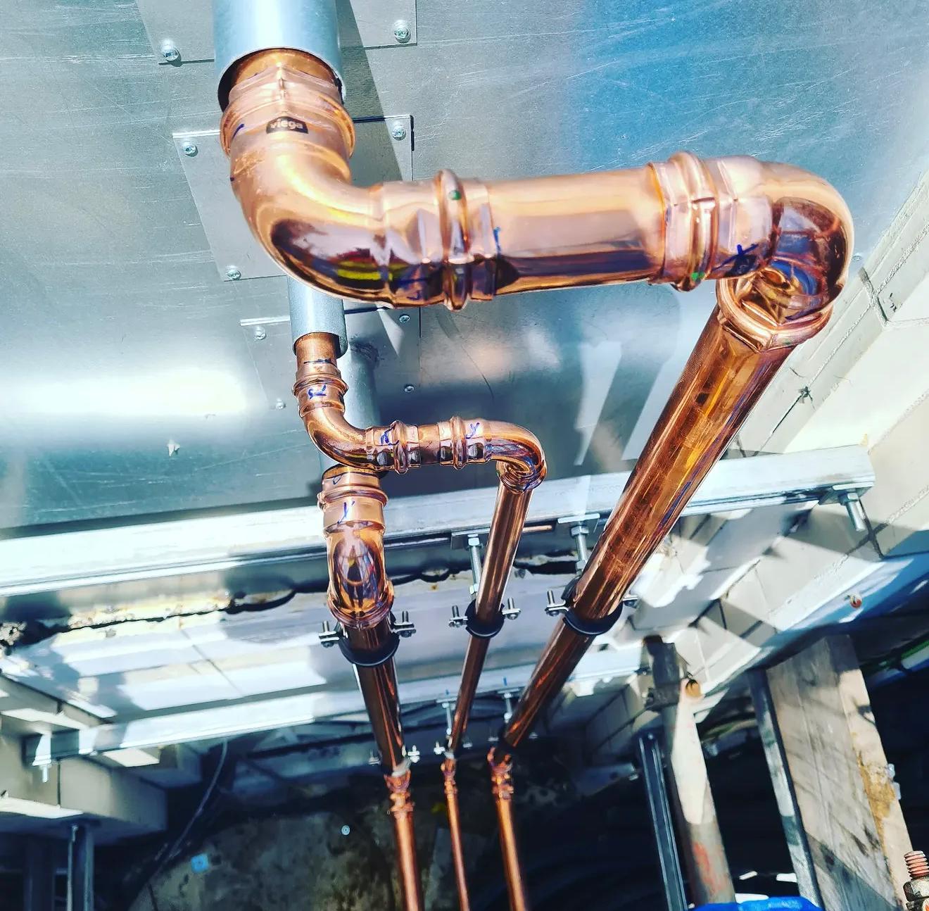 Close-up of installed copper pipework and press fittings