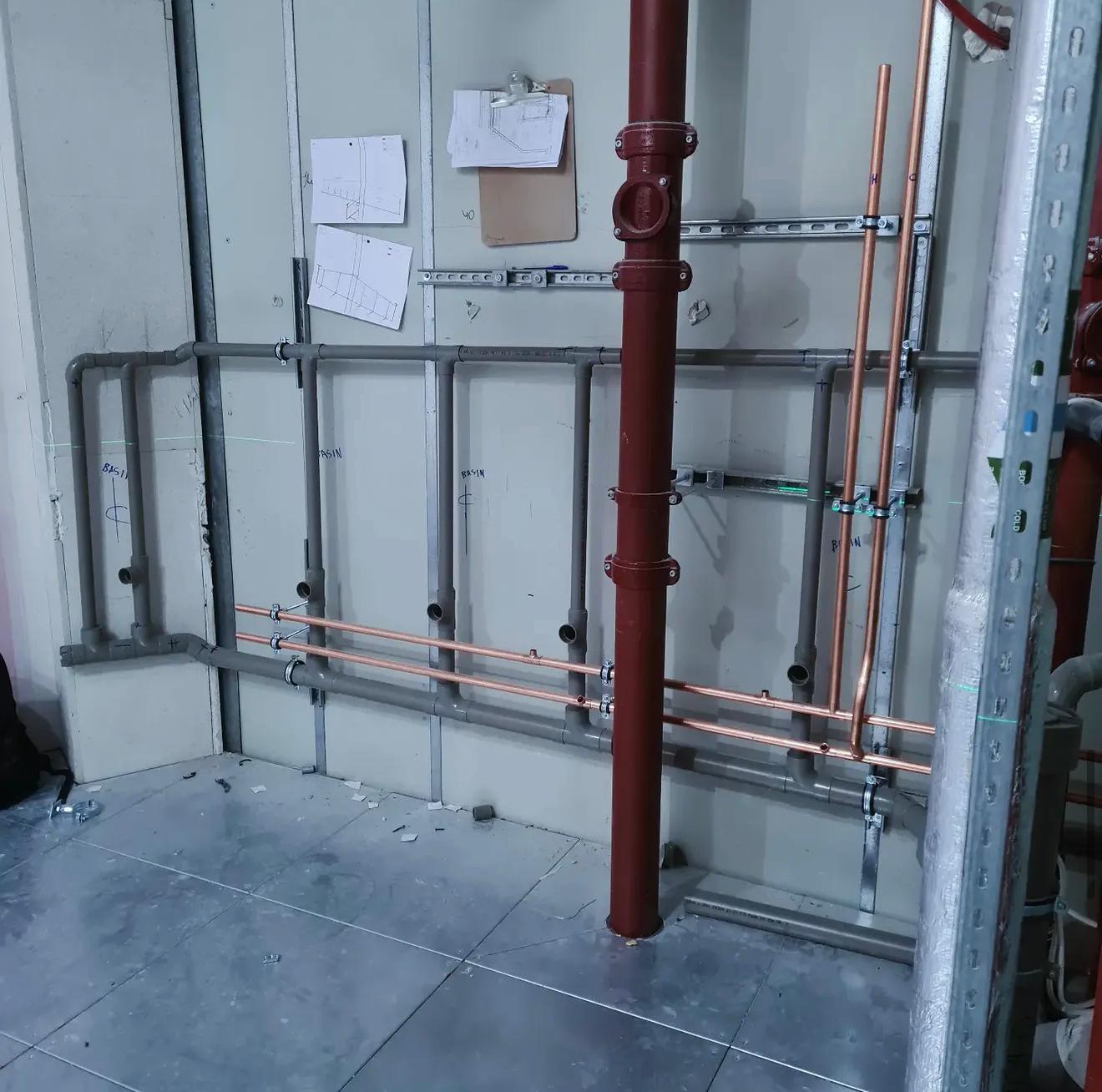 Exposed copper and grey pipework on site